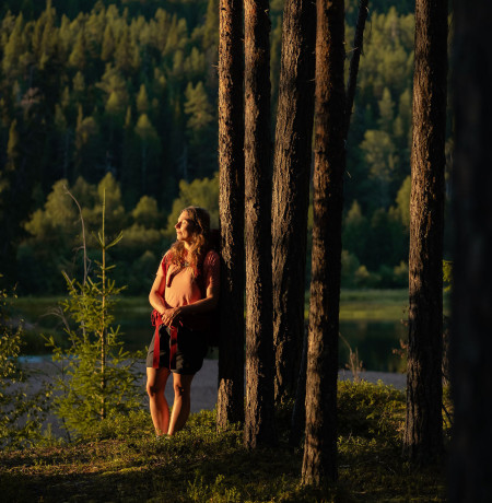Retkeilijä nojaa puuhun ja nauttii maisemista, Ruka-Kuusamo, kuva Jani Kärppä