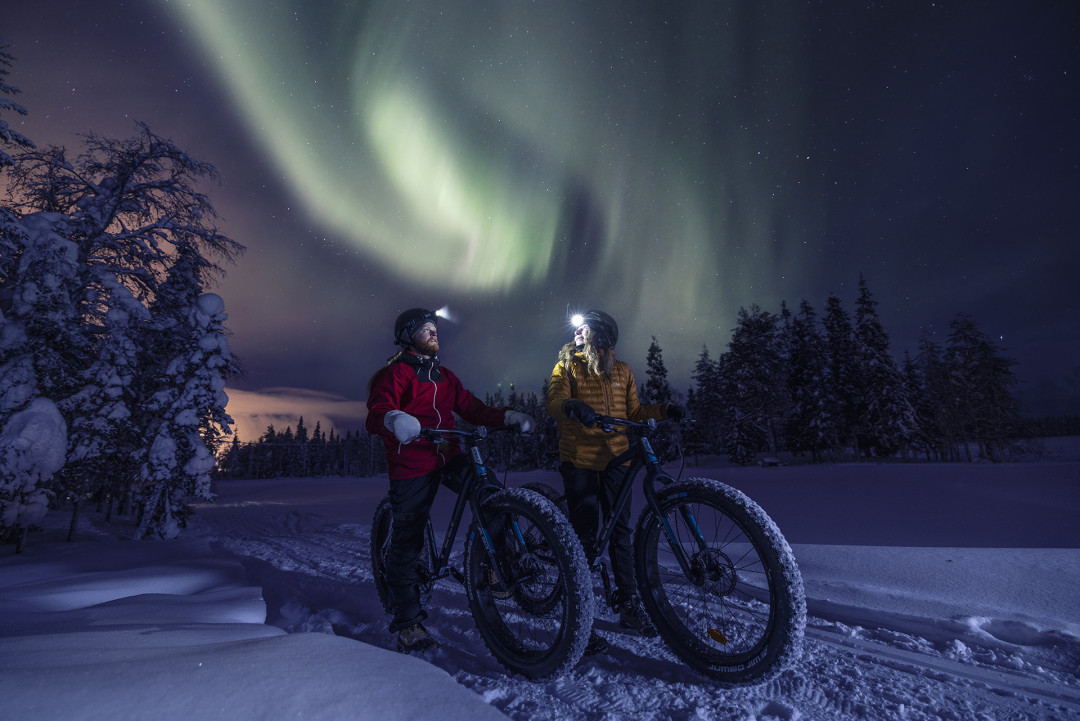 Fatbike-pyöräretkellä talvella revontulien alla