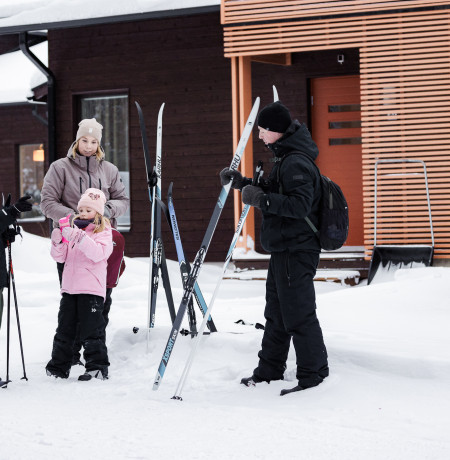 Perhe lähdössä hiihtämään Holiday Club Kuusamon Tropiikin huoneistojen luona. Kuva Mikko Santasalo