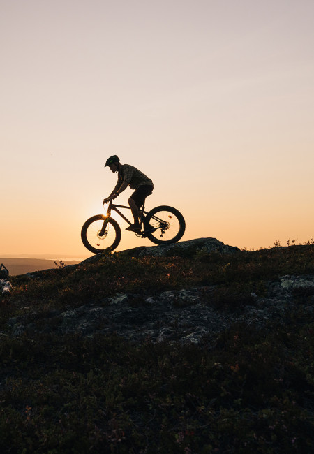 Maastopyöräilijä Rukan huipulla auringonlaskussa, Ruka-Kuusamo
