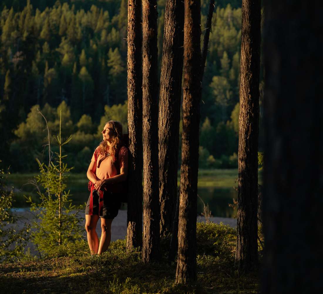 Retkeilijä nojaa puuhun ja nauttii maisemista, Ruka-Kuusamo, kuva Jani Kärppä