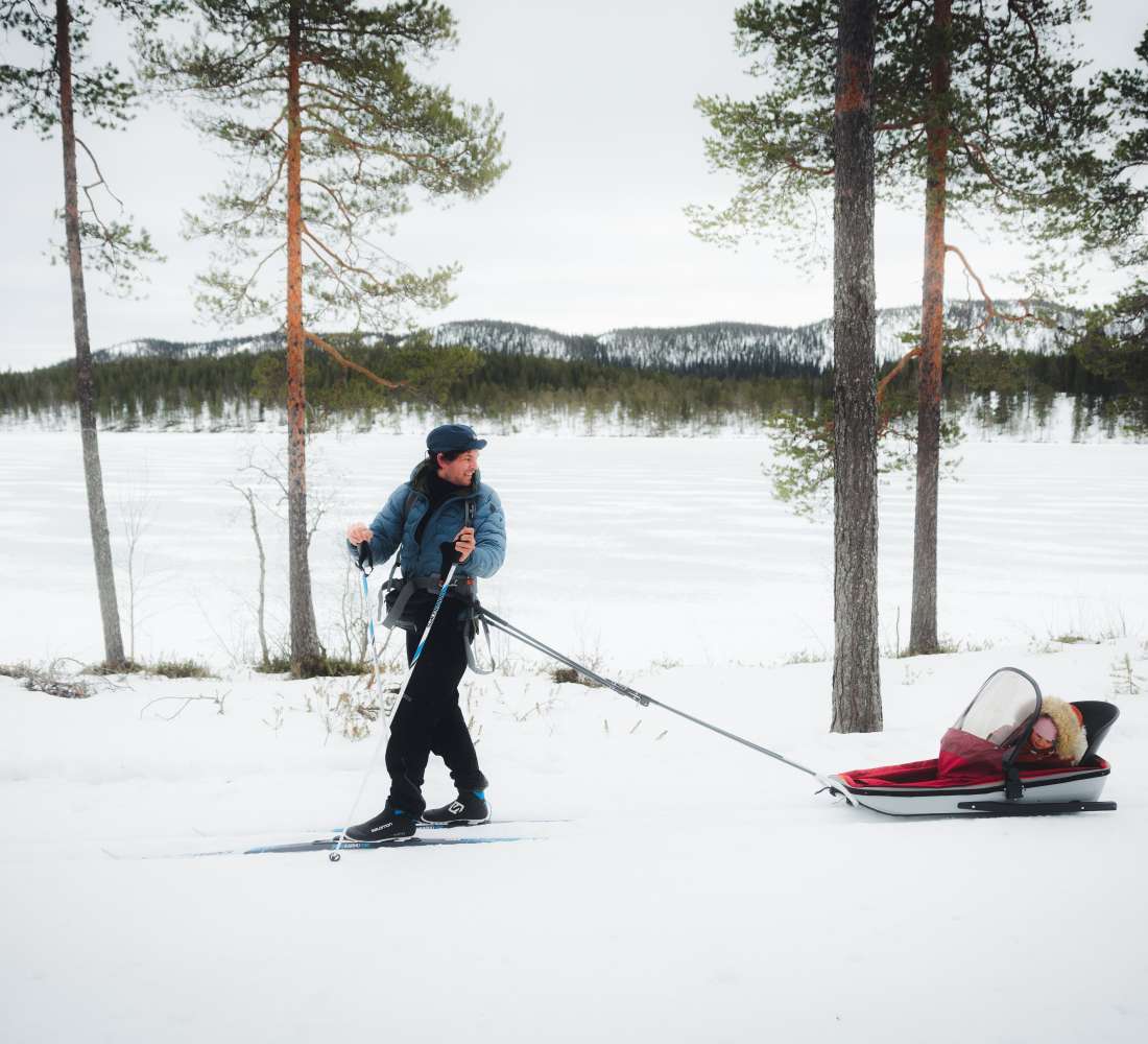 Maastohiihtäjä ladulla, lapsi mukana ahkiossa. Kuva Mikko Santasalo