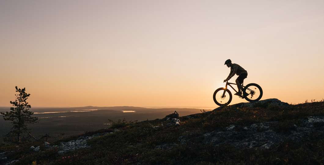 Maastopyöräilijä Rukan huipulla auringonlaskussa, Ruka-Kuusamo