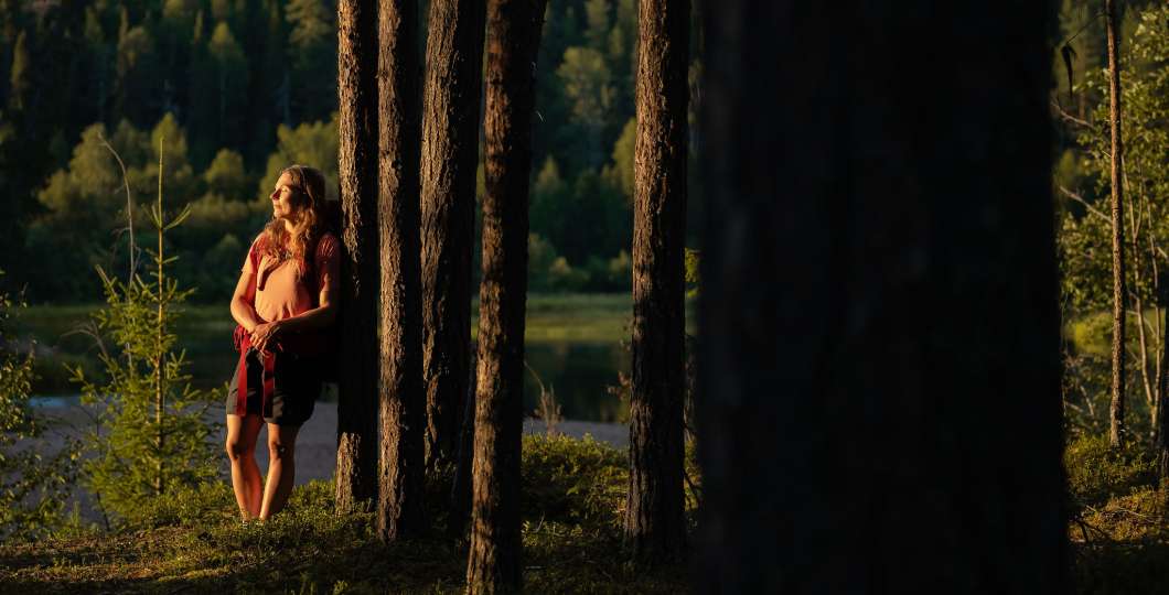 Retkeilijä nojaa puuhun ja nauttii maisemista, Ruka-Kuusamo, kuva Jani Kärppä