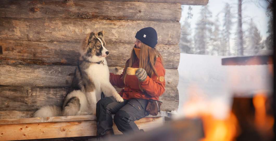 Nainen ja koira tauolla nuotiolla. Kuva Harri Tarvainen