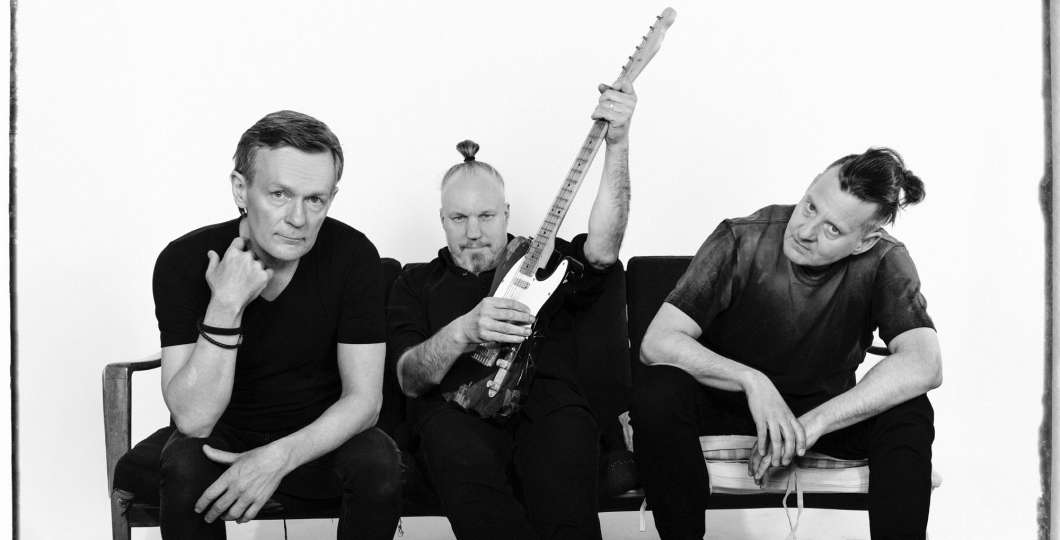 Kuvassa Teleks yhtye sohvalla katsoen kameraan mustavalkoisessa kuvassa. 