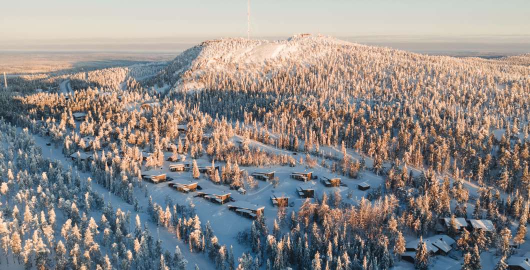 Ilmakuva Rukalodgesta, taustalla Juhannuskallio ja Rukan rinteet. Kuva Mikko Santasalo
