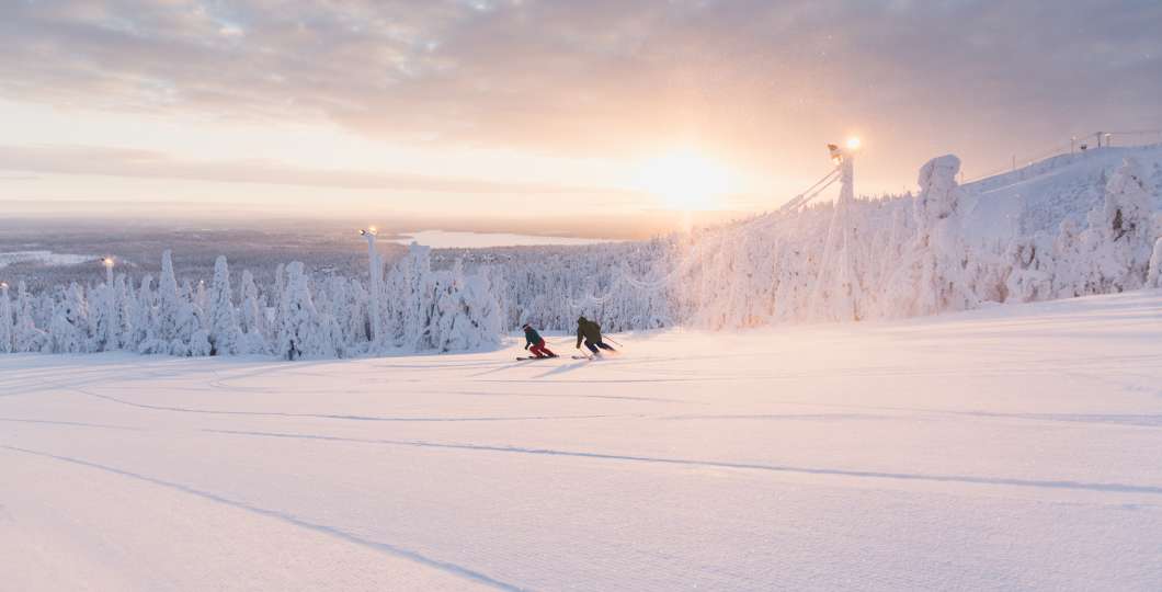 Laskettelijat ilta-auringossa Rukan rinteillä. 