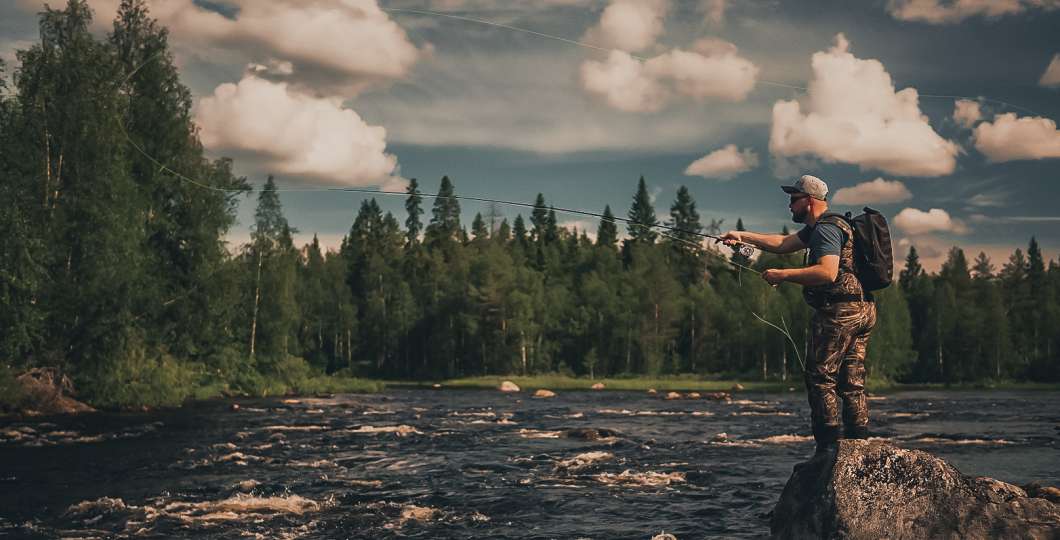 Kalastaja heittää perhoa kivellä Ruka-Kuusamossa